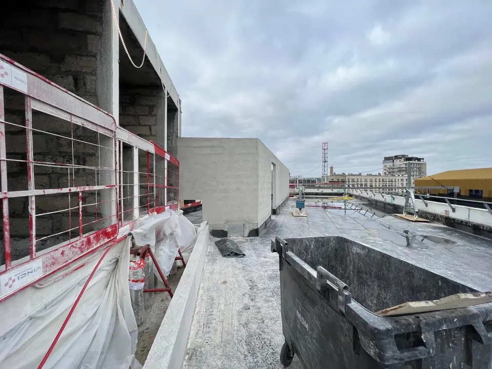 Toiture en cours de finition — étanchéité et locaux techniques en arrière-plan.