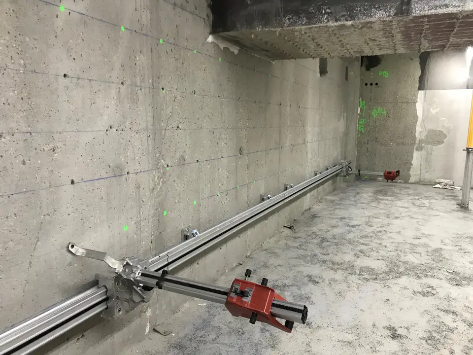 Dispositif de mesure d'ouverture de fissure installé sur voile, avec rail de référence.