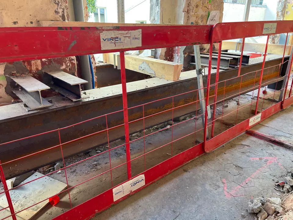 Poutre de reprise provisoire du chevalement — profilés HEB en cours de mise en place pour transférer les charges en phase travaux (chantier Vinci Construction).