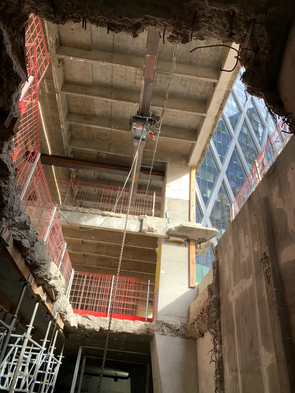 Vue intérieure depuis le bas — dalles étagées en cours de démolition, bâtiment mitoyen visible en fond.